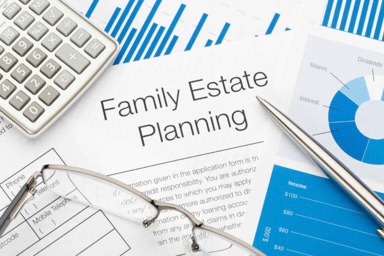 Family estate planning document with charts, calculator, and pen prepared by living trust preparers in San Jose.