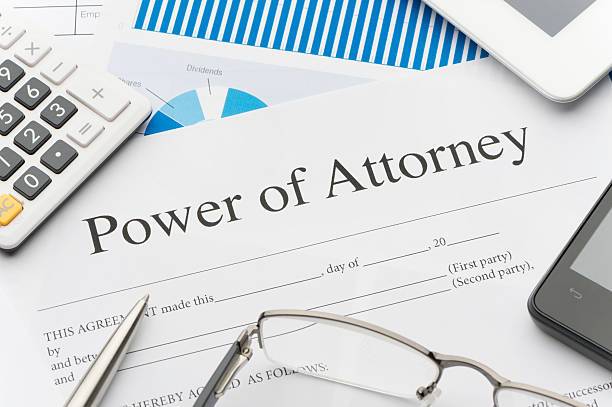 Power of Attorney document on a desk with pen, glasses, and financial charts, symbolizing legal authority and estate planning