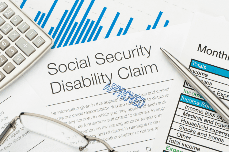 Approved Social Security Disability Claim form with financial charts, calculator, and pen representing SSDI help in San Jose.