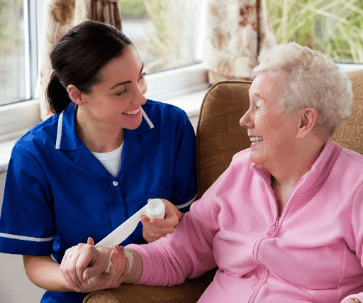 Caregiver assisting a smiling elderly woman at home—representing IHSS advocacy and application support services in San Jose.