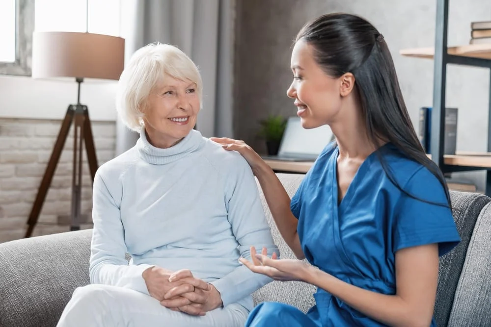 A caring healthcare professional speaking with a smiling elderly woman, symbolizing the supportive process of navigating an SSDI appeal.