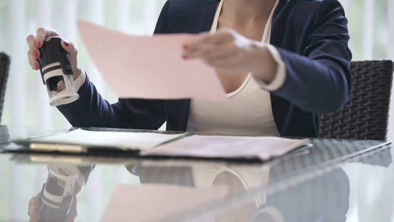 Notary public stamping and verifying official documents at a desk in San Jose