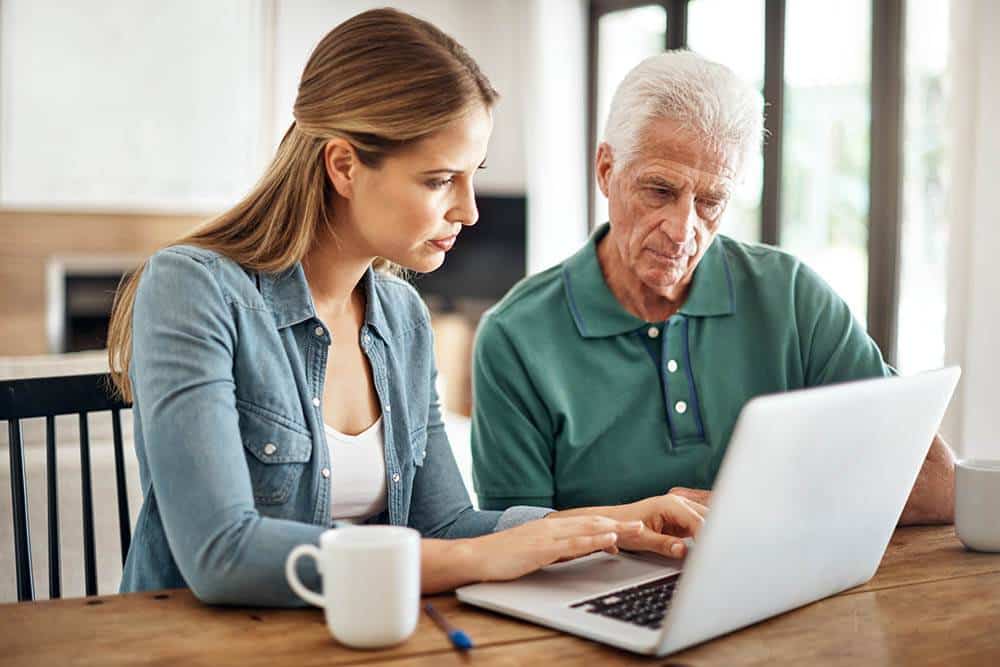 Two people working on a laptop.