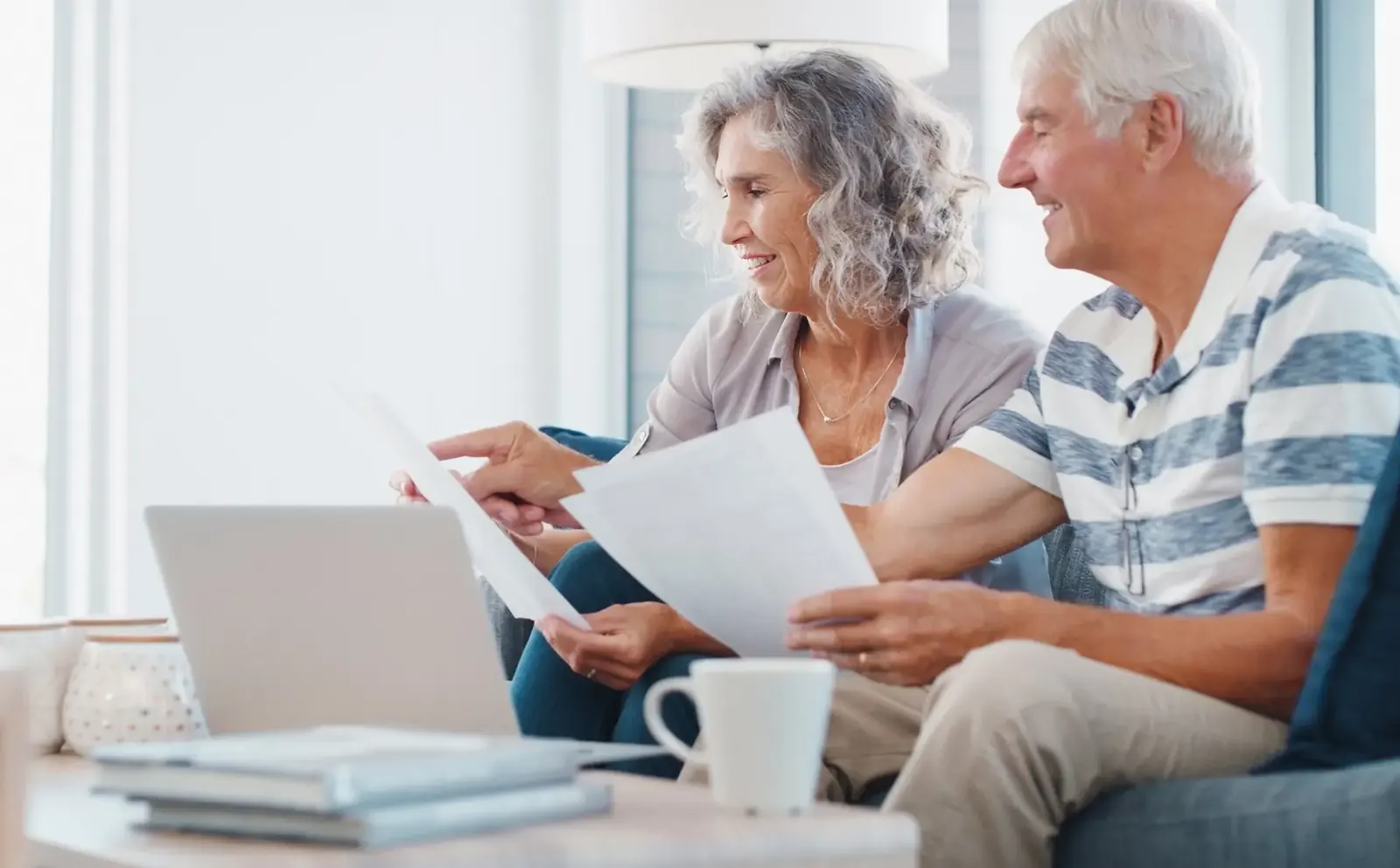 California senior couple reviewing Prop 13 reassessment exemption and spousal property documents at home before recording